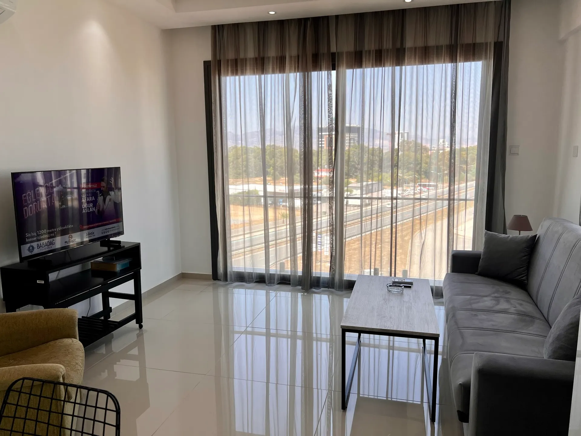Living room — TV and a wide city-view window