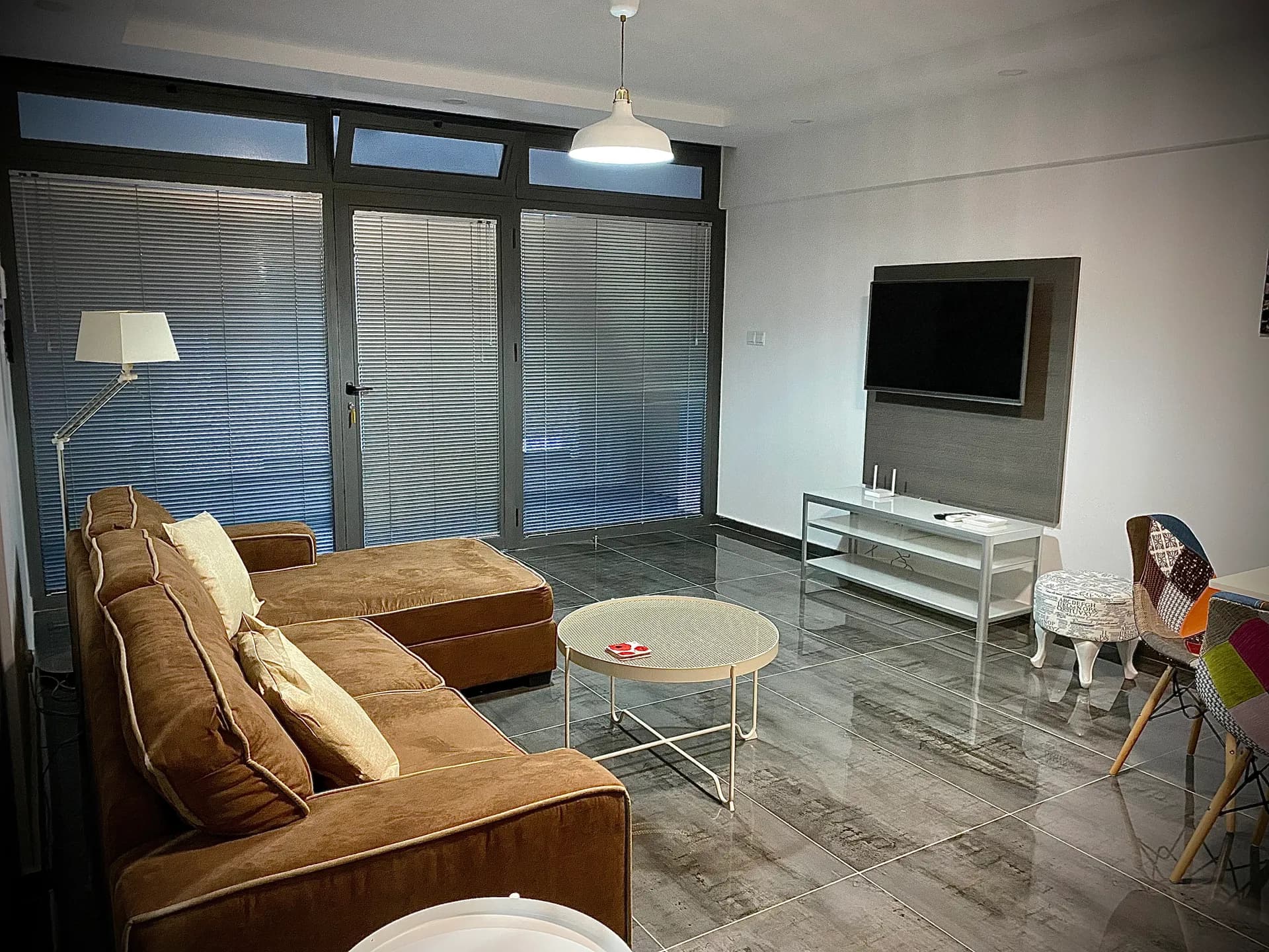 Living area — corner sofa, TV and glass entrance