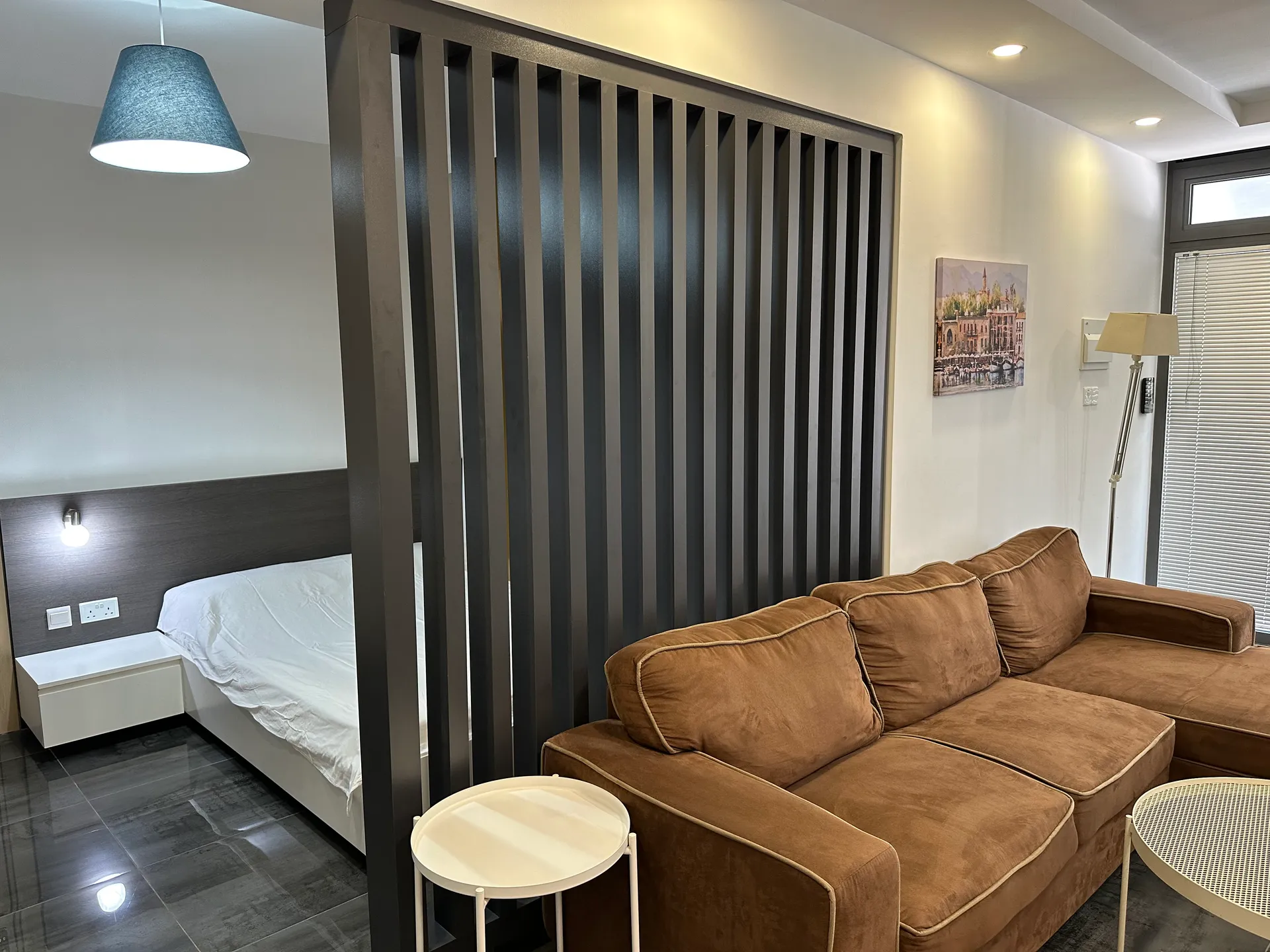 Separate sleeping area — double bed behind a slat divider